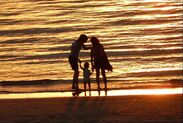 family near ocean at sunset